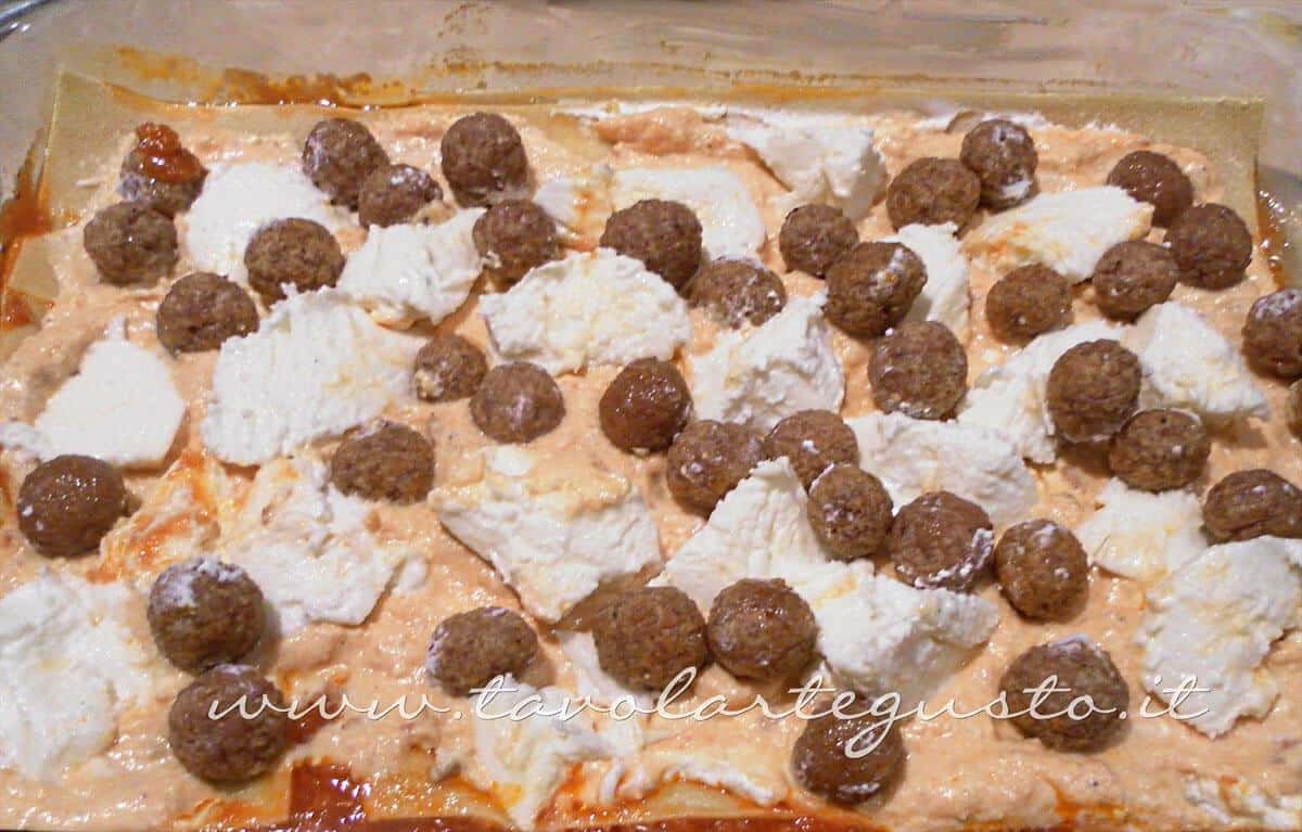 Adagiare uno strato di ricotta, mozzarella e polpettine - Ricette Lasagne napoletane Adagiare uno strato di ricotta, mozzarella e polpettine - Ricette Lasagne napoletane