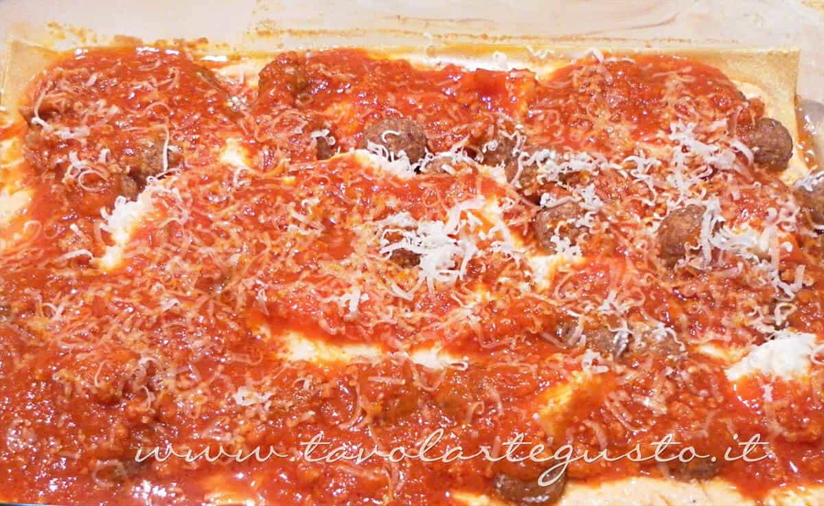 Aggiungere ragù e una spolverata di grana - Ricette Lasagne napoletane Aggiungere ragù e una spolverata di grana - Ricette Lasagne napoletane
