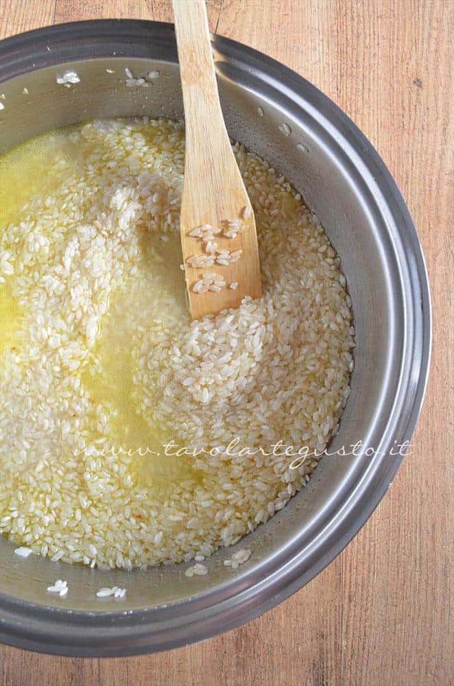 Aggiungere il brodo vegetale al riso - Ricetta Bordura di riso con crema di carciofi e crostini di Fiore Sardo