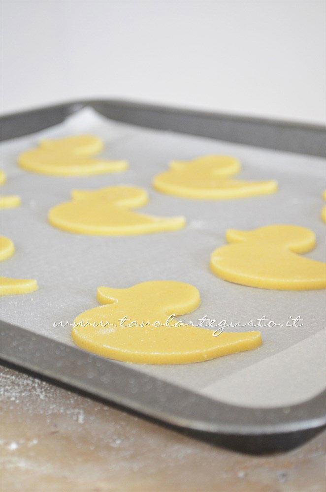 Adagiare i biscotti in una teglia -  Ricetta Biscotti di Pasqua Pulcini decorati in Pasta di Zucchero