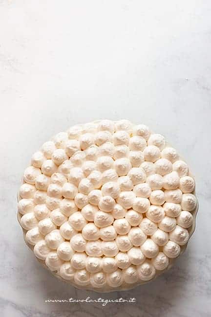 Completare il tiramisù alle fragole con uno strato di crema - Ricetta Tiramisù alle Fragole