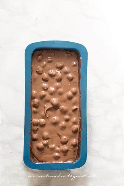 Versare nel guscio di cioccolato il mix di cioccolati e nocciole - Ricetta Torrone dei morti - Ricetta di Tavolartegusto