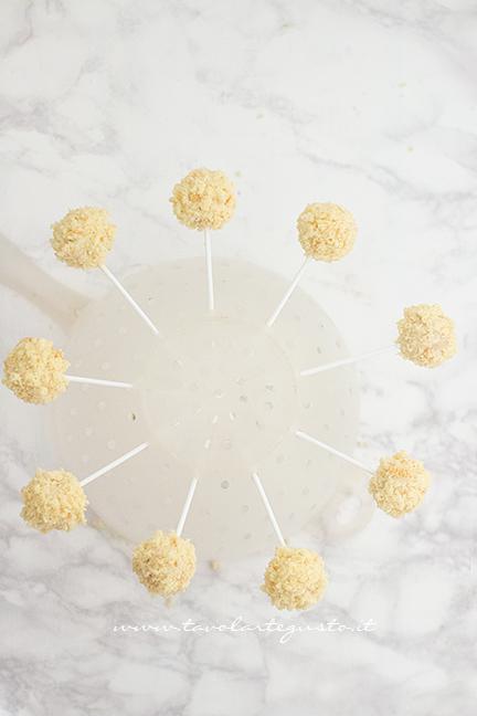 Fare asciugare i cake pops mimosa su una colapasta - Ricetta Cake pops Mimosa