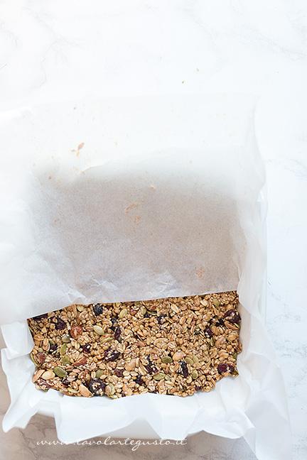 Trasferire il composto in una teglia e appiattire bene -Ricetta Barrette ai Cereali