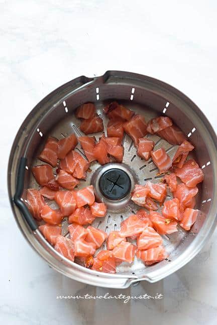 Tagliare a pezzettini il salmone fresco - Ricetta Risotto con scarola