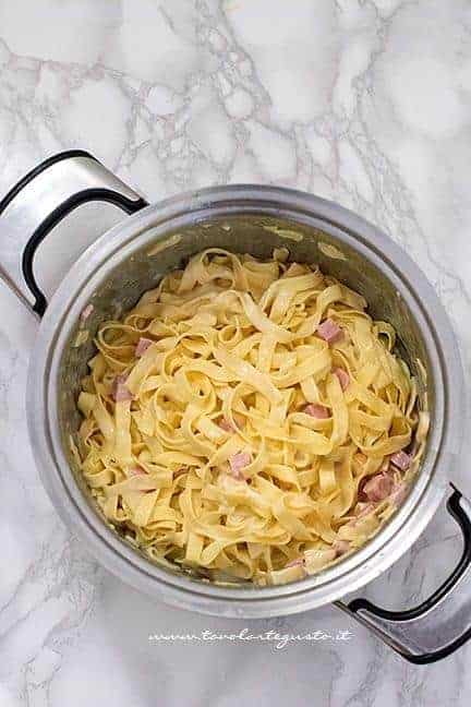 Mescolare la pasta con besciamella e latte - Ricetta Pasta al forno bianca - Ricetta di Tavolartegusto