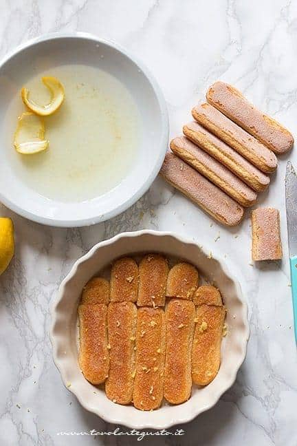 inzuppare i savoiardi nella bagna al limoncello - Ricetta Tiramisù al limone