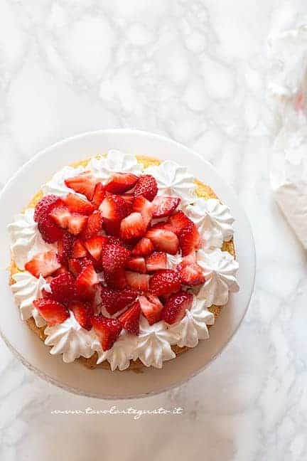 Farcire la torta con fragole in pezzi e panna montata - Ricetta Torta panna e fragole