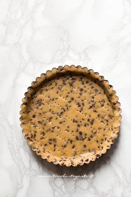 Foderare con la frolla cookie uno stampo per crostata - Ricetta Crostata cookies