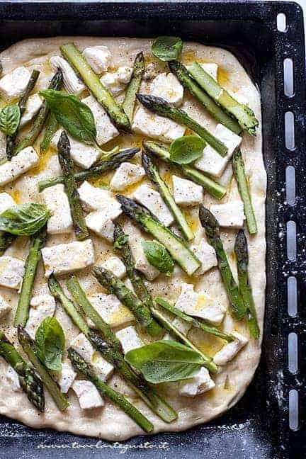 condire la pizza con asparagi, crescenza, olio e basilico - Ricetta pizza con asparagi