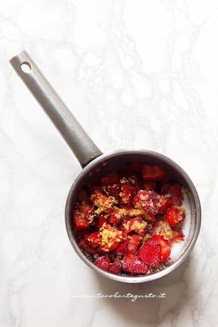 fragole in pezzi, zucchero e buccia di limone - Ricetta Rotolo alle fragole
