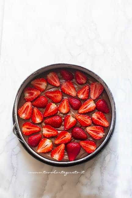 Aggiungere le fragole sulla superficie della torta - Ricetta Torta cioccolato e fragole