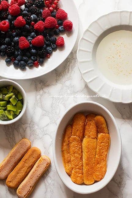 inzuppare i savoiardi nella bagna al limone - Ricetta Tiramisù alla frutta