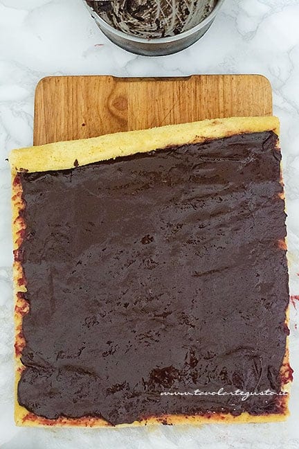 Aggiungere la ganache al cioccolato e arrotolare - Ricetta Tronchetto di Natale