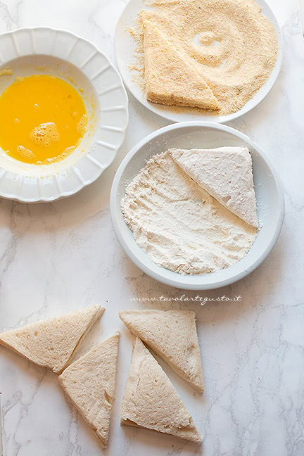 impanare le fette di pane ripiene di mozzarella - Ricetta mozzarella in carrozza al forno