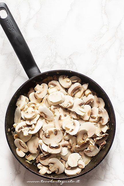 aggiungere i funghi al condimento della pasta alla boscaiola