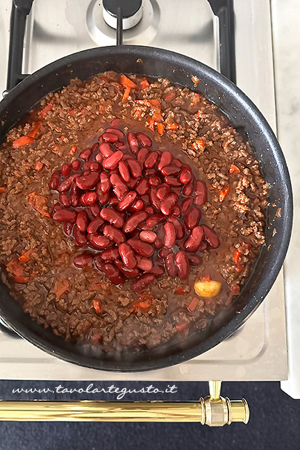 aggiungere i fagioli alla carne per il burrito